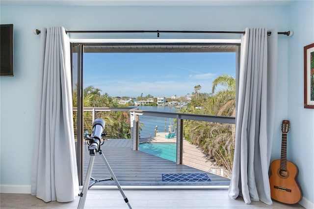 doorway to outside with a healthy amount of sunlight and a water view