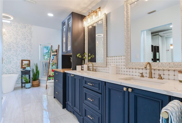 bathroom featuring vanity, tasteful backsplash, toilet, and a bathing tub