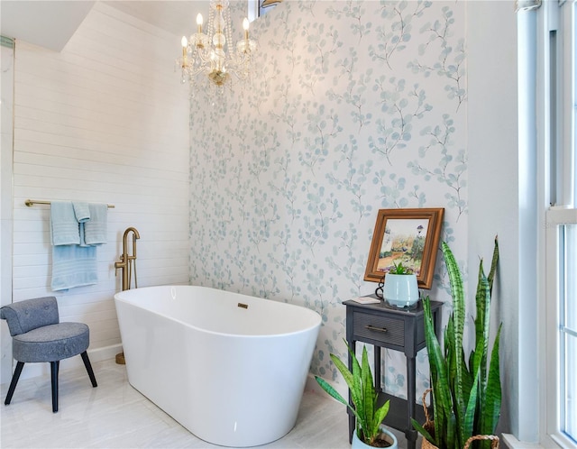 bathroom featuring a tub and an inviting chandelier