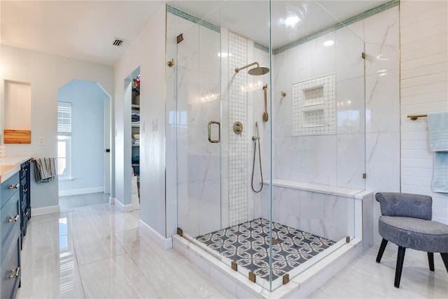 bathroom with a shower with door and vanity