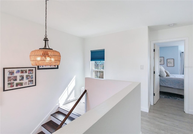 hall featuring hardwood / wood-style floors and an inviting chandelier