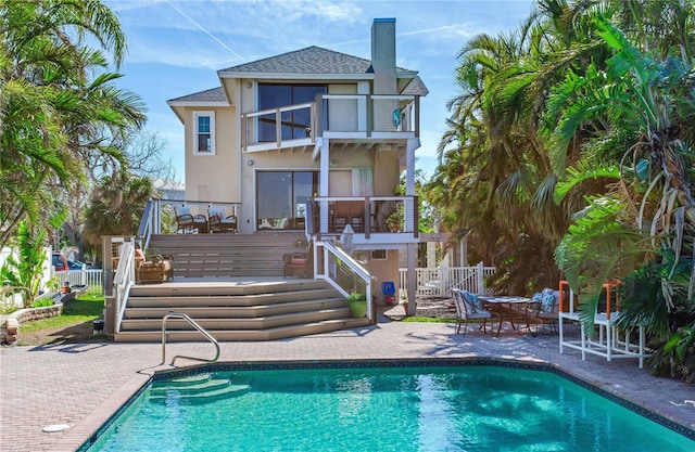 rear view of property featuring a patio and a balcony