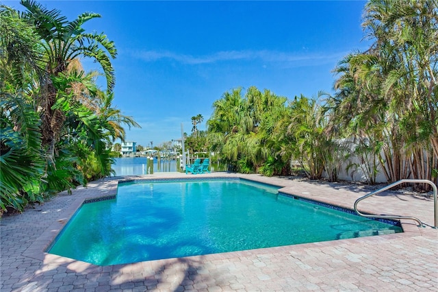 view of swimming pool featuring a water view and a patio area