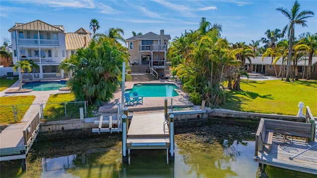 dock area with a yard, a balcony, a water view, and a patio