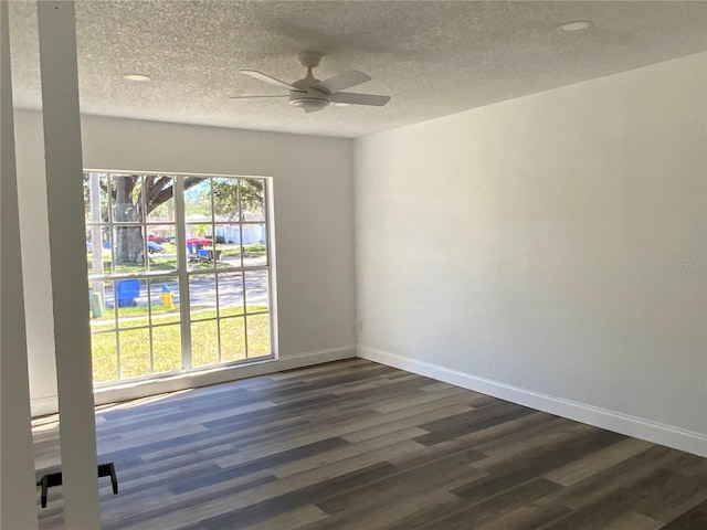 empty room with dark hardwood / wood-style flooring, a textured ceiling, and ceiling fan