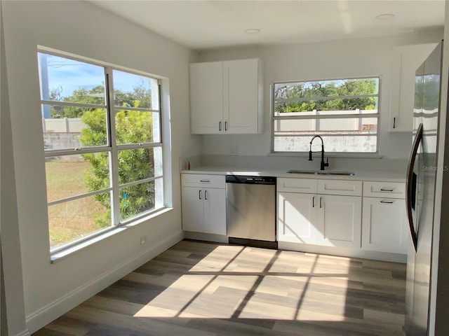 kitchen with appliances with stainless steel finishes, white cabinetry, plenty of natural light, and sink