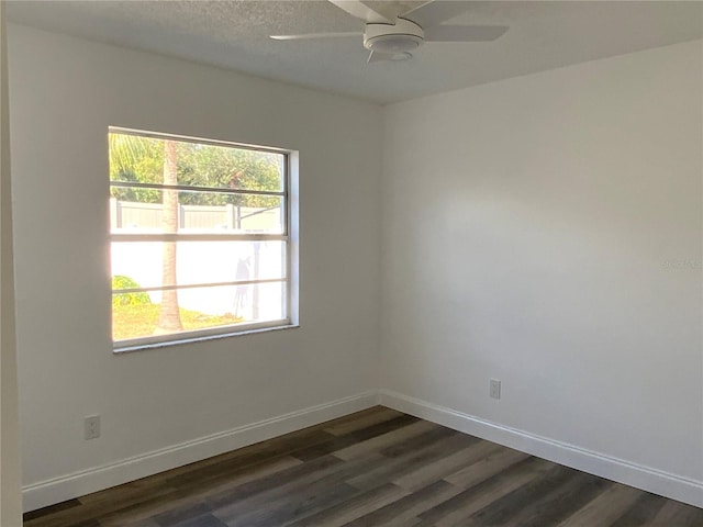 empty room with dark hardwood / wood-style floors and ceiling fan