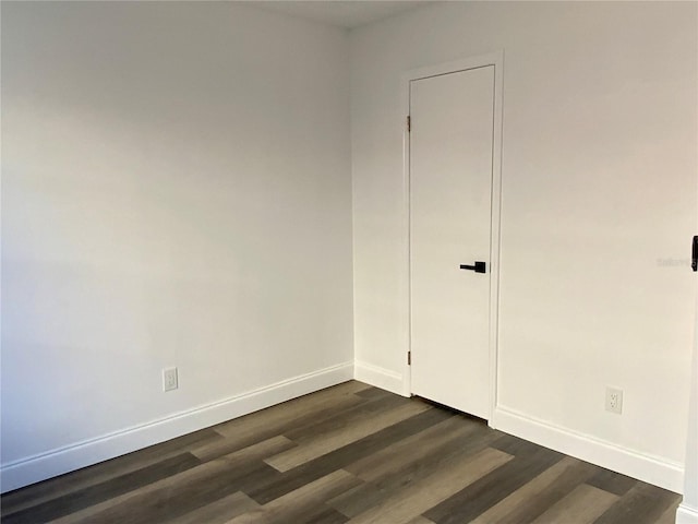 unfurnished room with dark hardwood / wood-style flooring