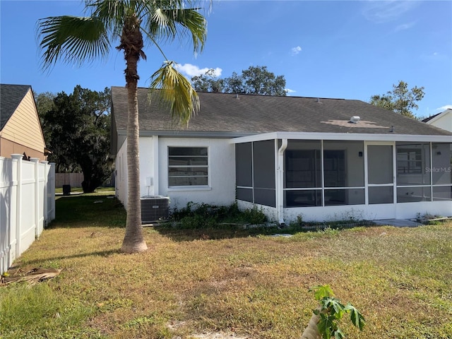 view of side of home with a sunroom, a yard, and cooling unit