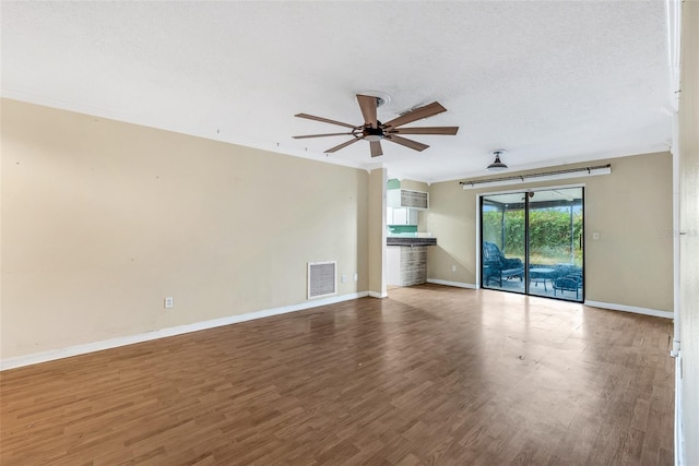 unfurnished living room featuring hardwood / wood-style flooring, ceiling fan, and a textured ceiling