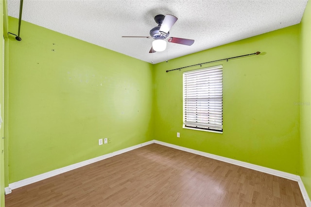 spare room with a textured ceiling, hardwood / wood-style flooring, and ceiling fan