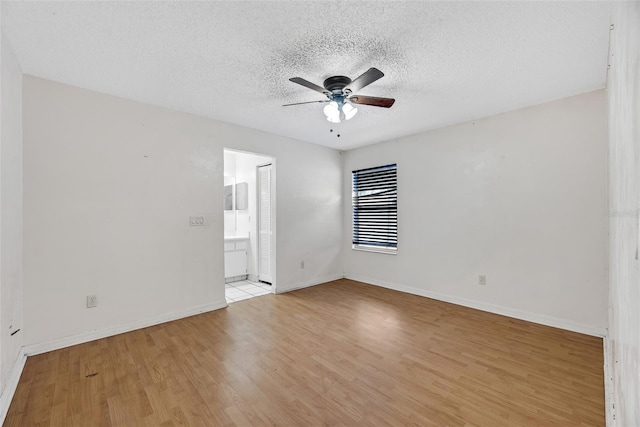 empty room featuring ceiling fan, light hardwood / wood-style floors, and a textured ceiling