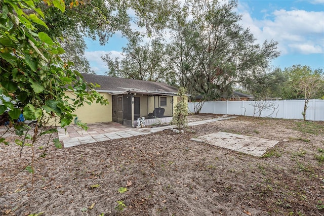 view of yard featuring a sunroom and a patio