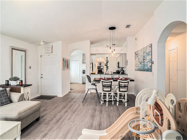 dining room featuring hardwood / wood-style floors and vaulted ceiling