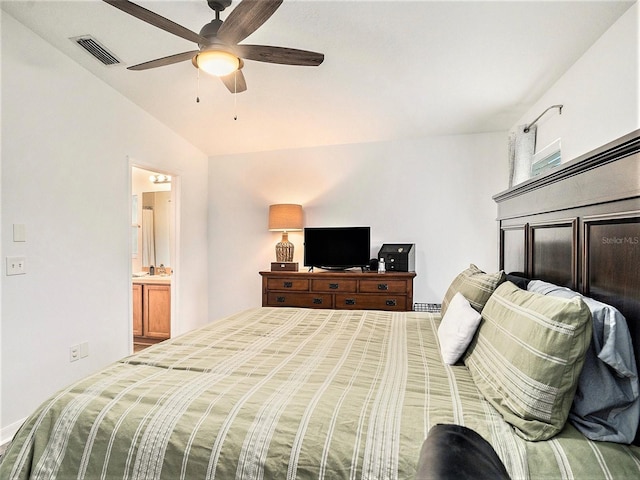 bedroom featuring vaulted ceiling, ensuite bath, and ceiling fan