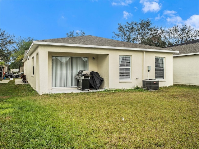 back of house with central air condition unit and a lawn