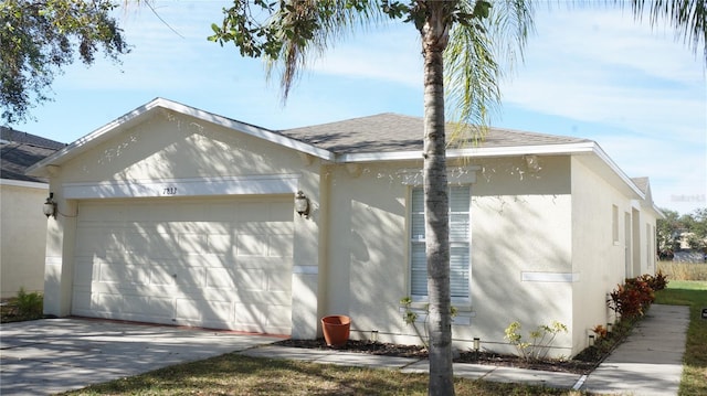 view of home's exterior with an attached garage, stucco siding, a shingled roof, and driveway