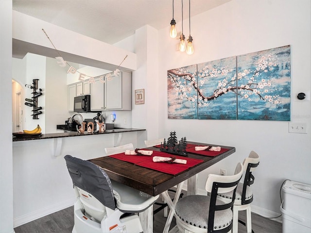 dining space with dark wood-type flooring and baseboards