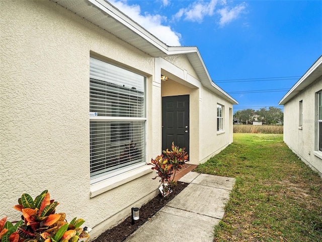view of property exterior with a lawn and stucco siding