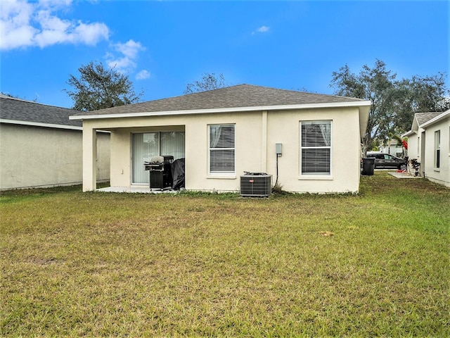 rear view of property with a yard, stucco siding, and cooling unit