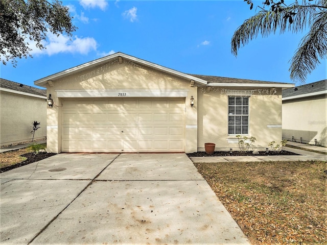 ranch-style house featuring driveway, stucco siding, and an attached garage