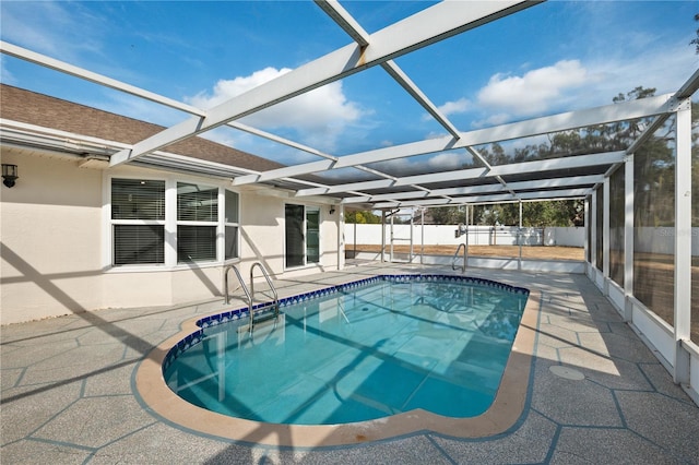 view of pool with glass enclosure and a patio