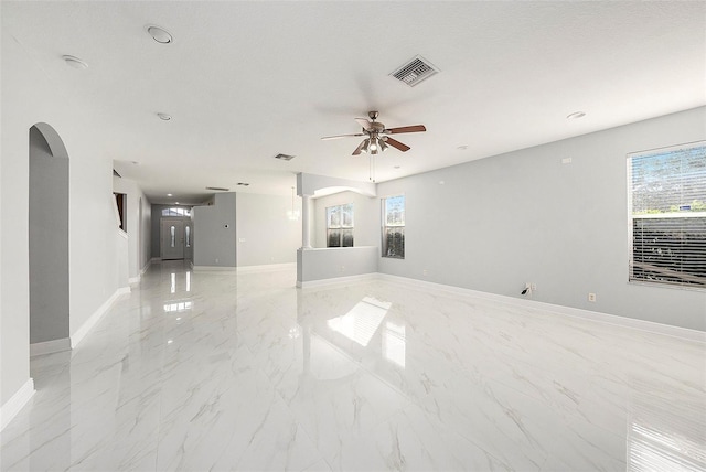 empty room with ceiling fan and a textured ceiling