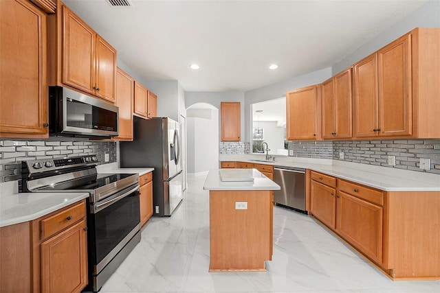 kitchen with backsplash, a center island, stainless steel appliances, and sink