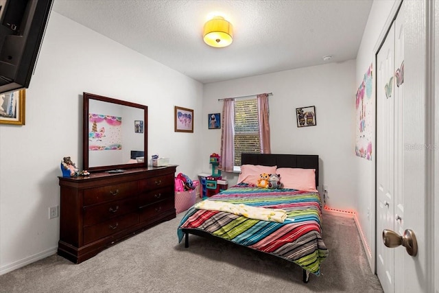 bedroom featuring a textured ceiling and light colored carpet