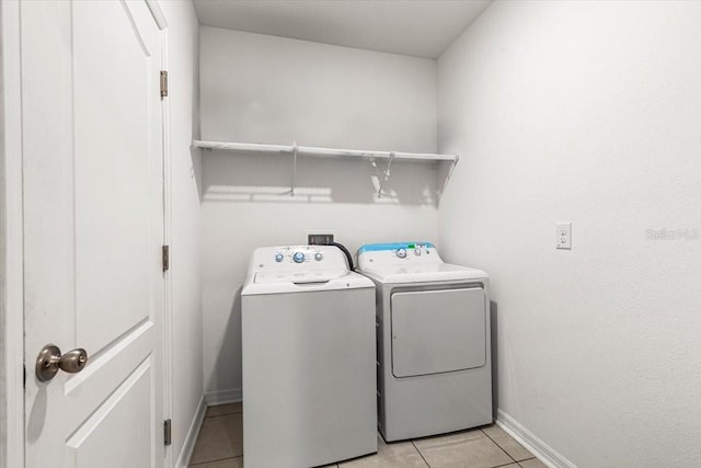 washroom with washer and clothes dryer and light tile patterned flooring