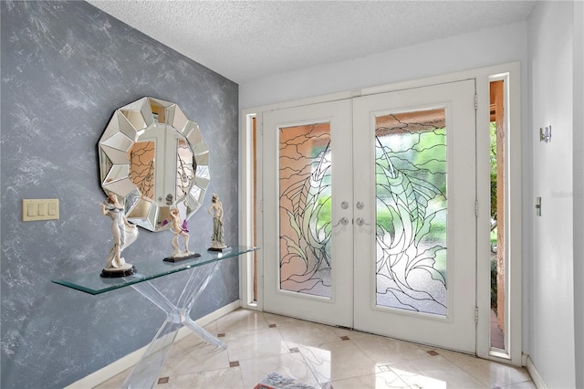 entryway with french doors and a textured ceiling