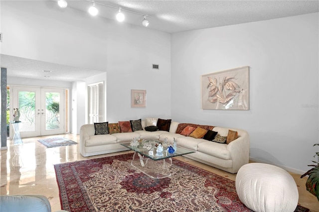 living room featuring french doors and a textured ceiling