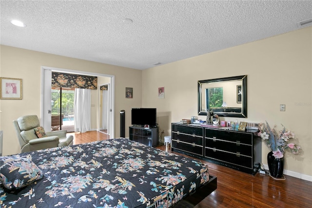 bedroom featuring a textured ceiling, dark wood-type flooring, and access to outside