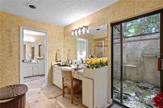 bathroom with vanity, a textured ceiling, and a shower with shower door