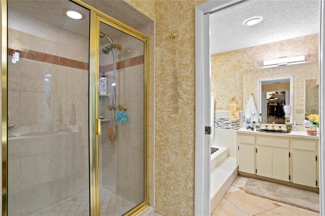 bathroom featuring tile patterned floors, vanity, a textured ceiling, and independent shower and bath