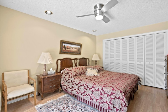 bedroom featuring ceiling fan, a closet, a textured ceiling, and hardwood / wood-style flooring