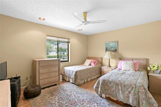 bedroom featuring ceiling fan, a textured ceiling, and light hardwood / wood-style flooring