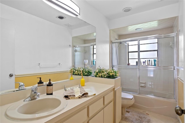 full bathroom with vanity, toilet, and shower / bath combination with glass door