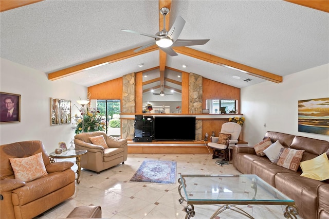 living room with vaulted ceiling with beams, ceiling fan, and a textured ceiling