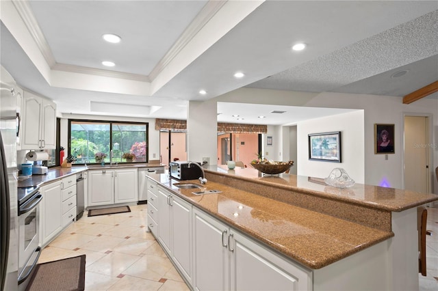 kitchen with a large island, stainless steel appliances, stone countertops, a breakfast bar, and white cabinets