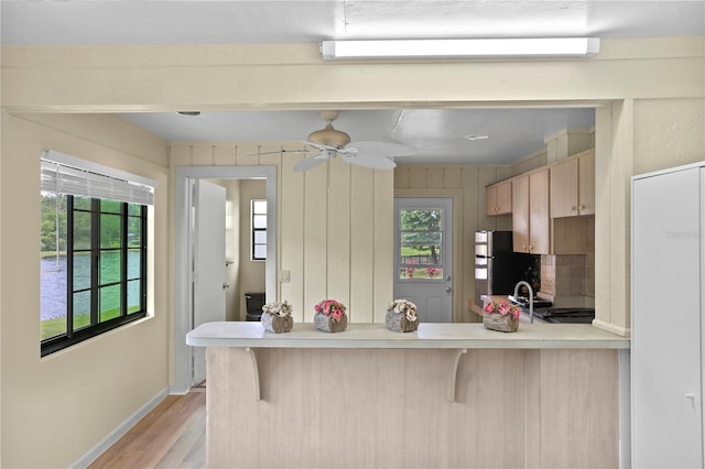 kitchen featuring a kitchen bar, kitchen peninsula, and a wealth of natural light