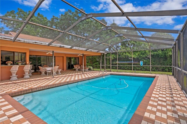 view of pool featuring a patio area, ceiling fan, and a lanai