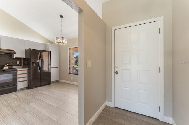 kitchen with vaulted ceiling, exhaust hood, black appliances, white cabinetry, and hanging light fixtures