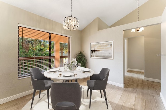 dining area featuring lofted ceiling, light hardwood / wood-style flooring, and a notable chandelier