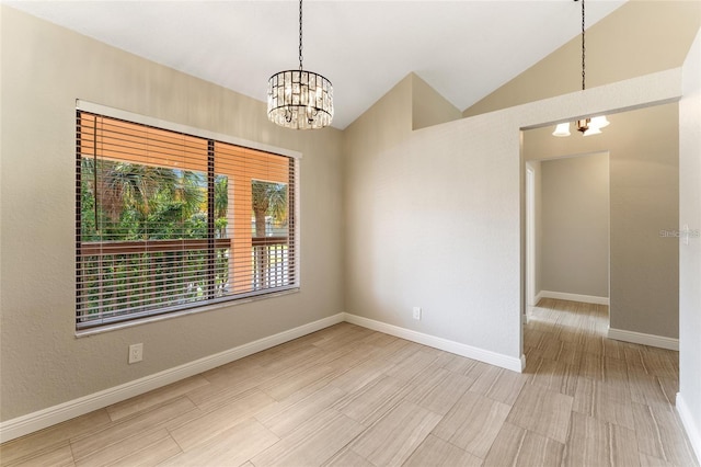 spare room with light hardwood / wood-style floors, vaulted ceiling, and a notable chandelier