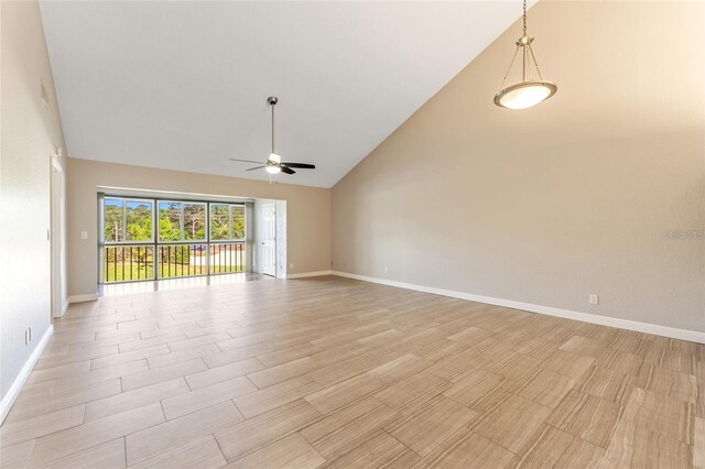 empty room featuring ceiling fan, light wood-type flooring, and high vaulted ceiling