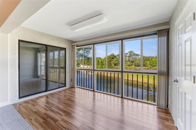 unfurnished sunroom featuring a water view