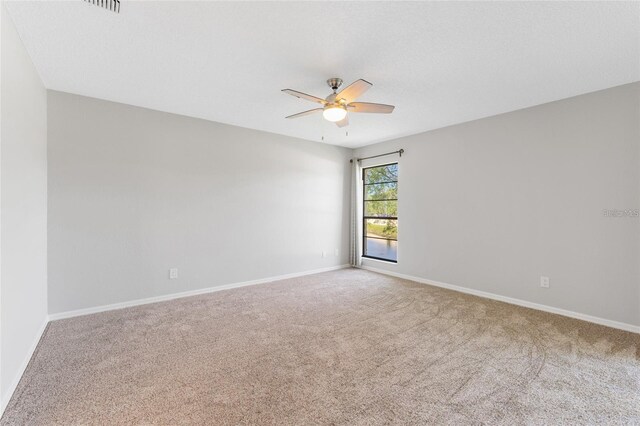 carpeted spare room with ceiling fan