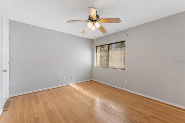 empty room with ceiling fan, light hardwood / wood-style floors, and a textured ceiling