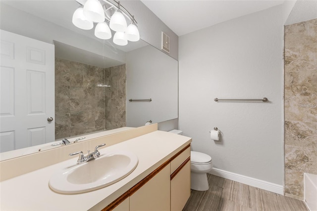 bathroom featuring vanity, toilet, wood-type flooring, and a tile shower